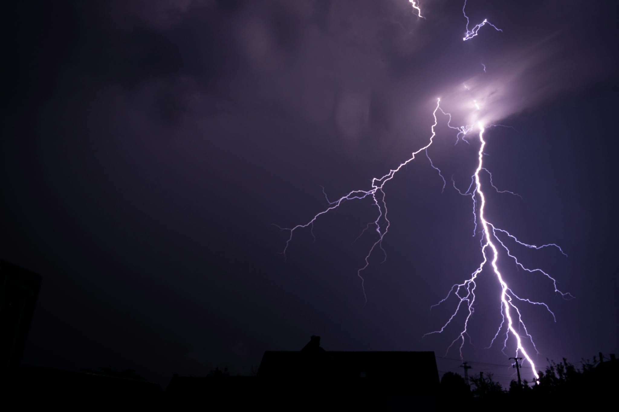 A vibrant lightning strike illuminating the night sky during a severe thunderstorm.